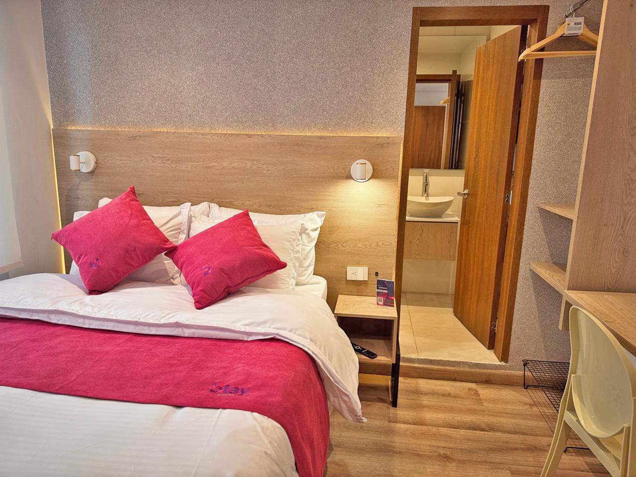 Suite Stay con detalles magenta y acabados en madera